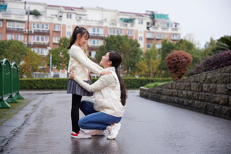 下雨天妈妈接送女儿上学图片