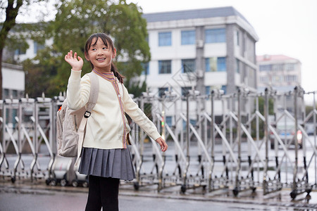 下雨天小女孩上学回头和家长告别背景图片