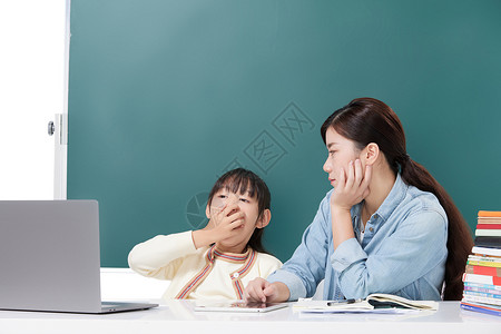 家长辅导困倦的女儿小学生学习高清图片