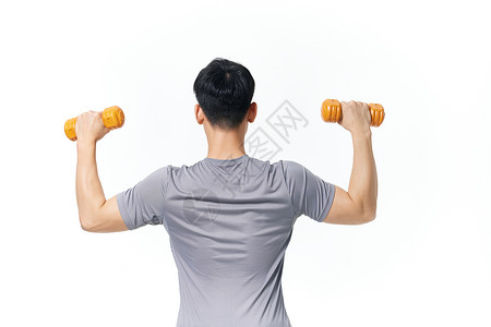 使用哑铃锻炼身体的男性背影高清图片