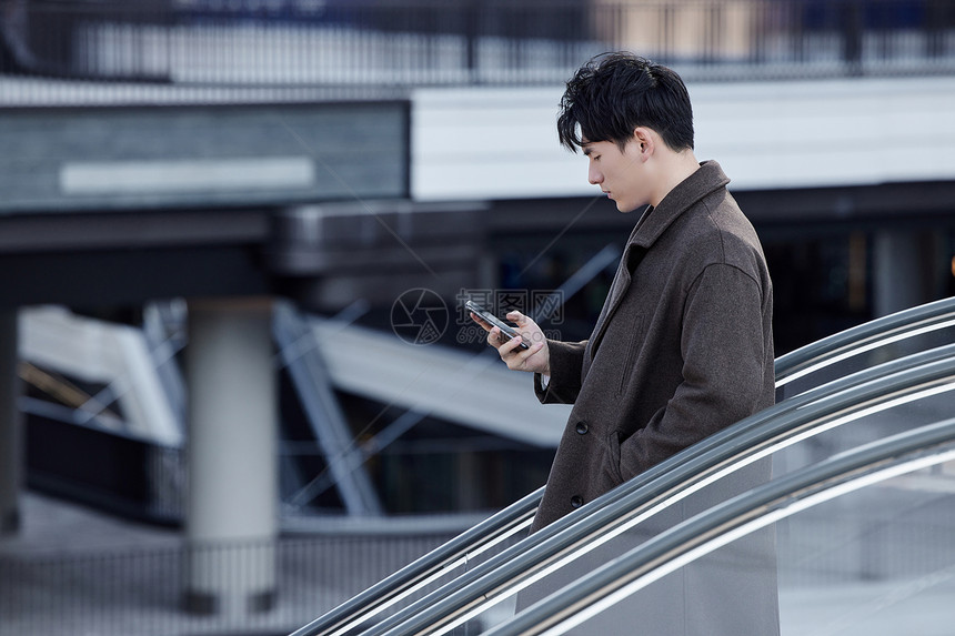 秋冬都市精英男性乘坐手扶电梯形象图片