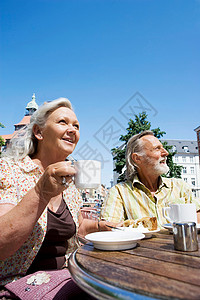 坐在阳光下喝着咖啡的老年夫妇图片