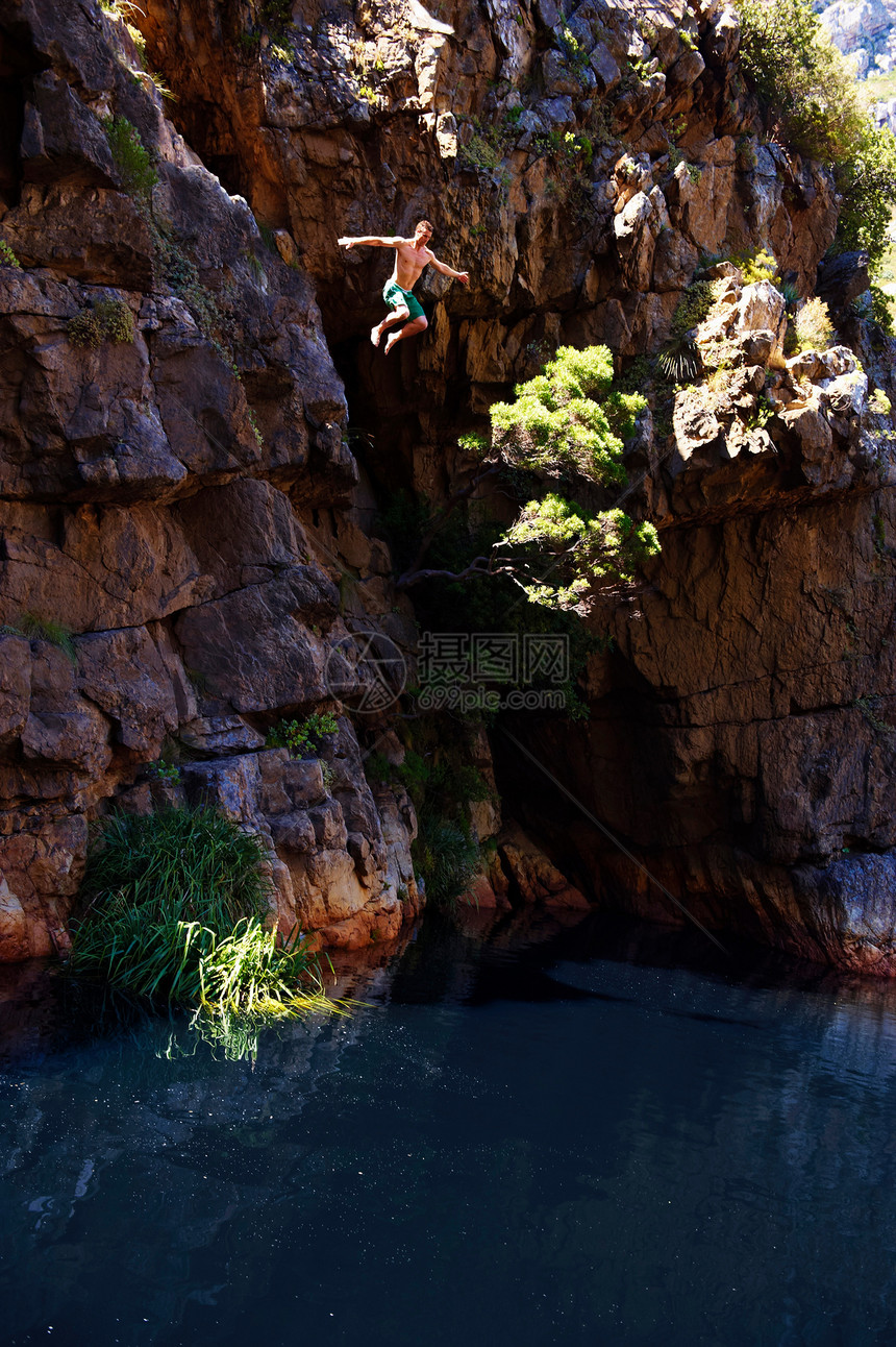 年轻人从悬崖跳入水中图片