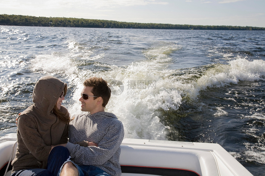 湖中的快艇上的一对情侣图片