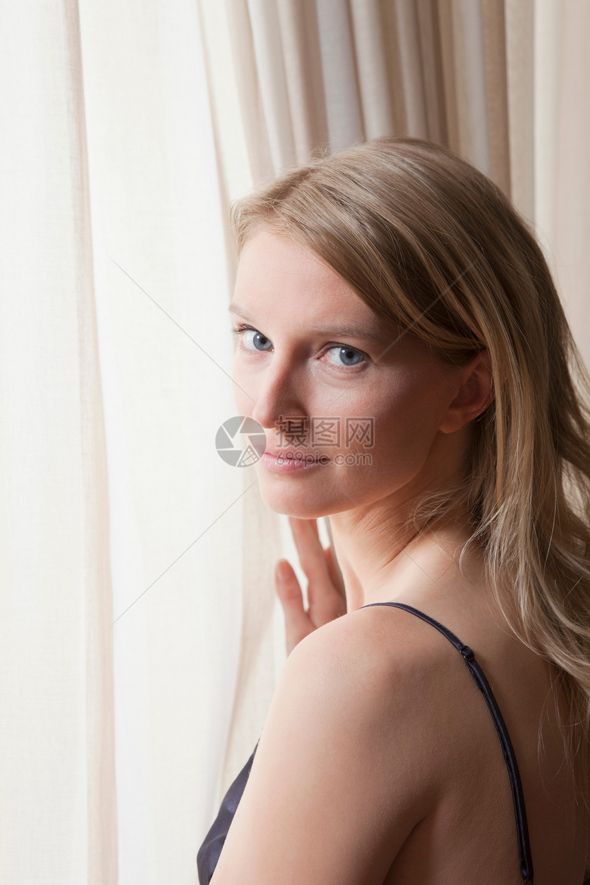 女人站在窗口图片