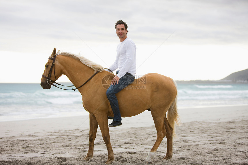 男人在海滩骑马图片