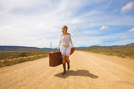 孤单的女人走在沙漠路上图片