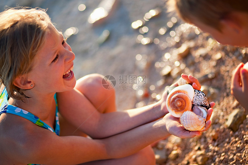 女孩在沙滩上发现海螺图片