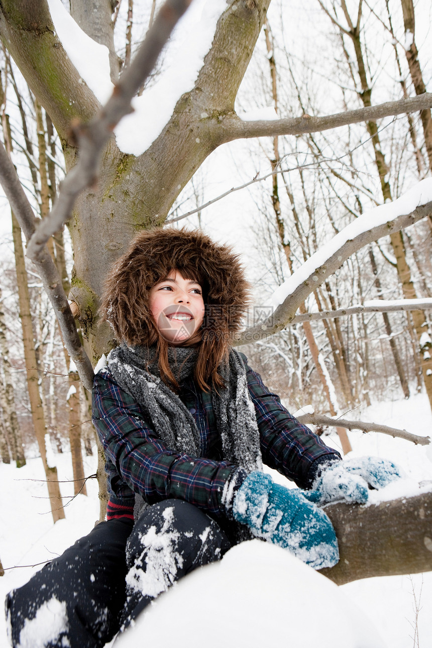 女孩坐在雪树下图片