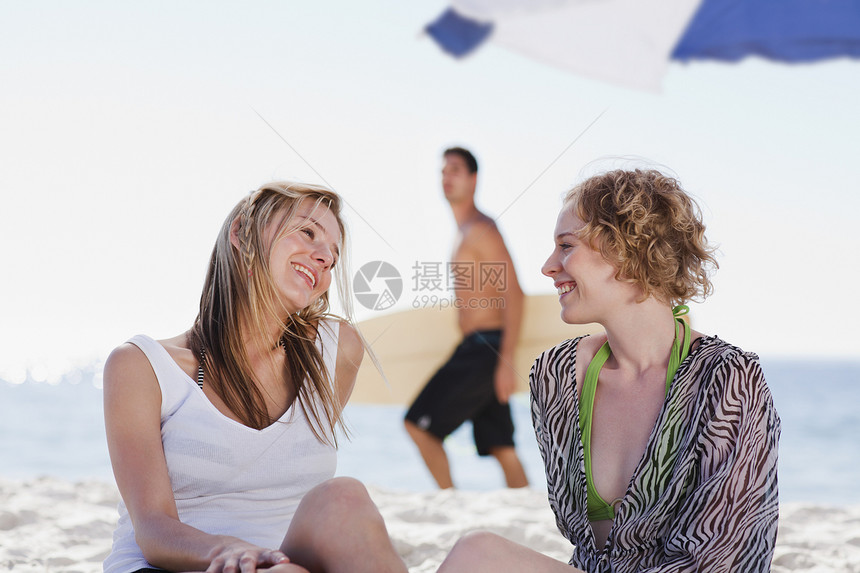 微笑的女人在海滩上说话图片