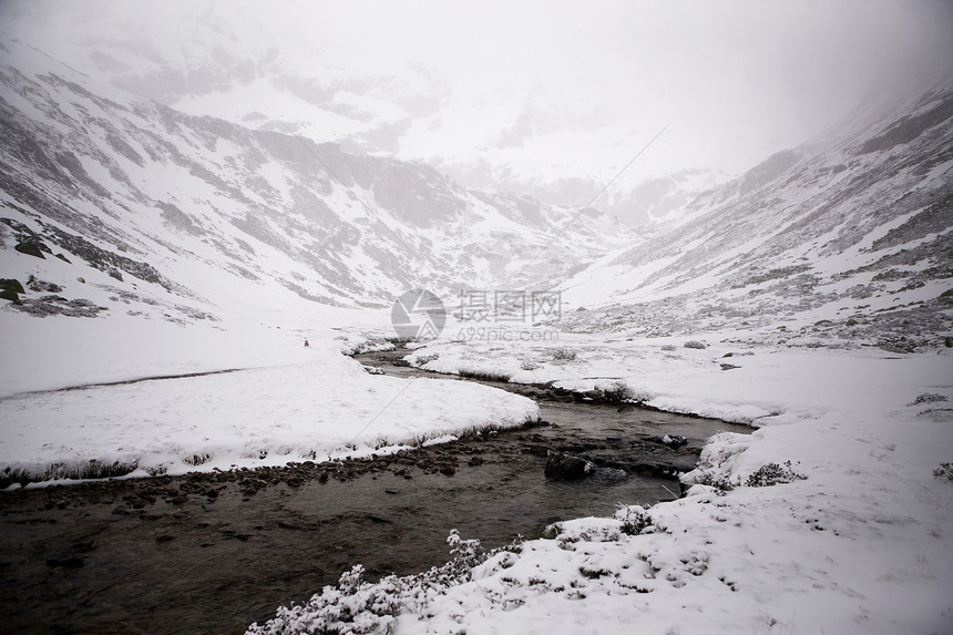 寒冷的河流雪山被雾笼罩图片