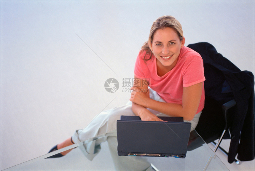 办公室使用笔记本电脑的女商人图片