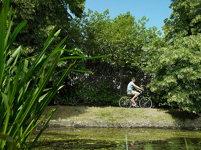男子在河岸骑自行车图片