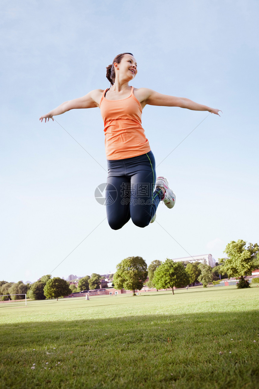 草地上跳跃的女性图片