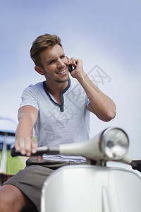 男人在摩托车上打电话背景图片