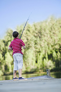 男孩在湖边码头钓鱼图片