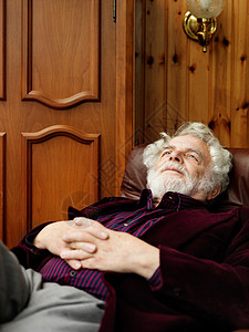 年长男子坐扶手椅放松图片