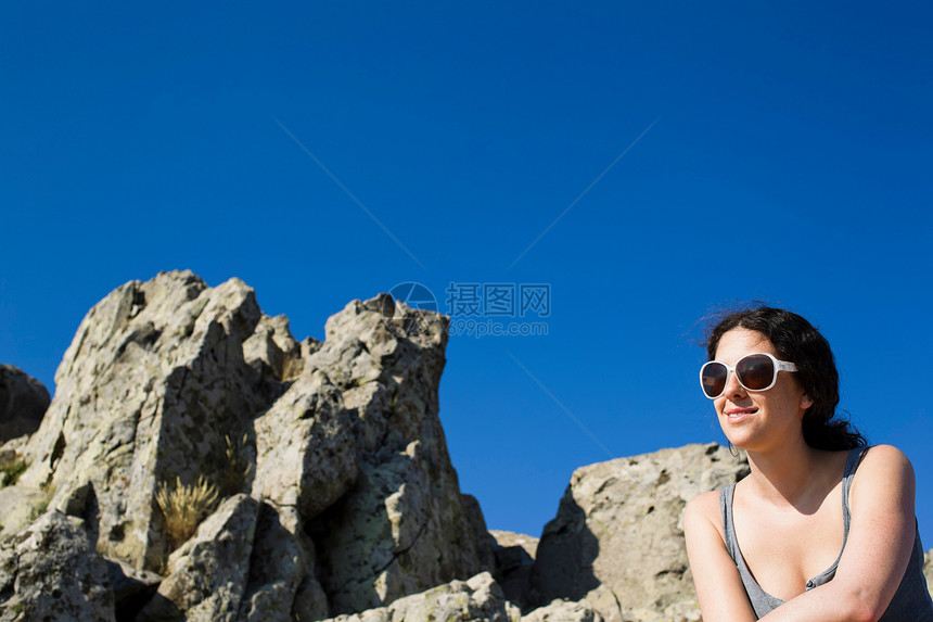 坐在岩石上的女人图片