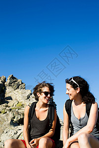 两个女人坐在岩石上聊天图片