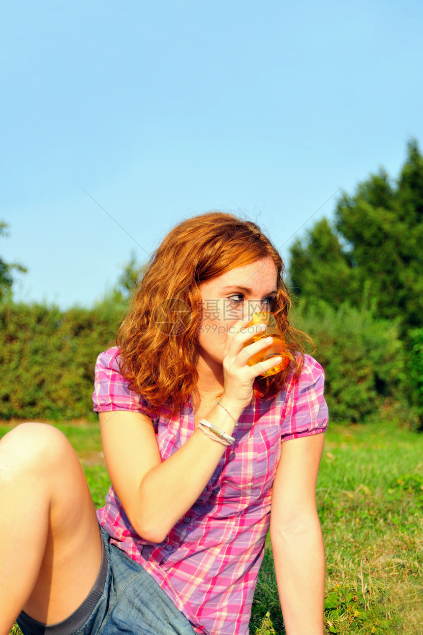 少女在后院喝果汁图片