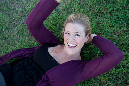躺在草坪上微笑的女人图片