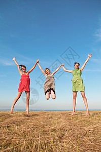 三个女孩在小麦田中玩耍图片