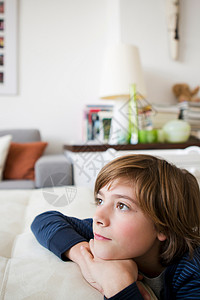 在客厅沙发上放松的男孩图片