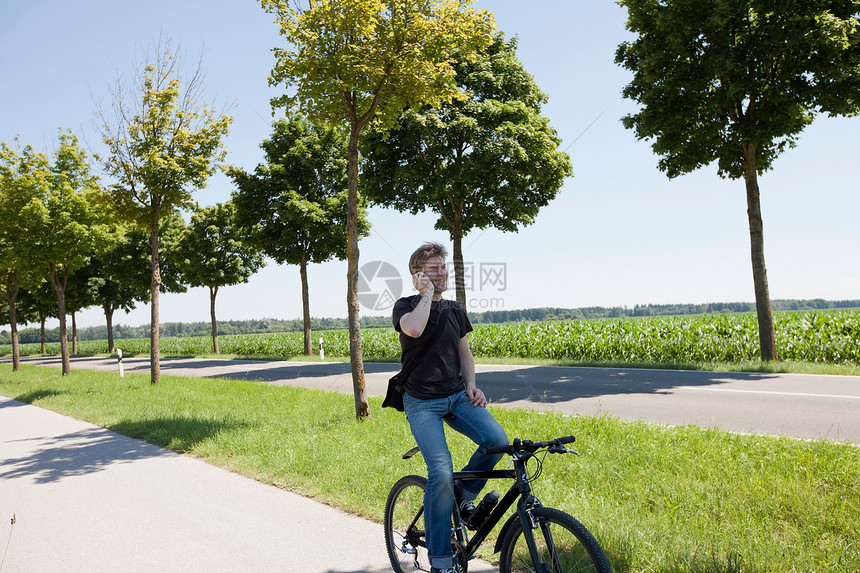 男人坐在自行车上打电话图片