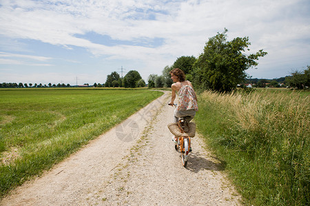 在农村公路上骑自行车的妇女图片