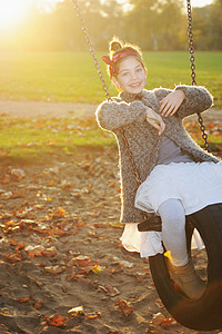 女孩在公园里玩秋千图片