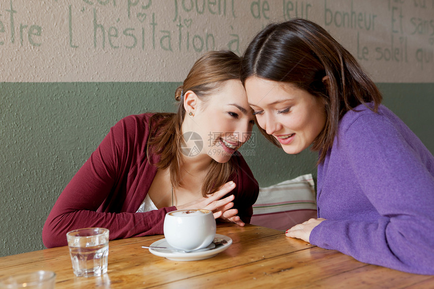 女人在咖啡厅里互相低语图片