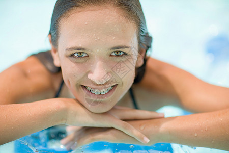 戴牙套的少女在游泳池里微笑图片