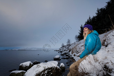 在雪中欣赏湖景的女性图片
