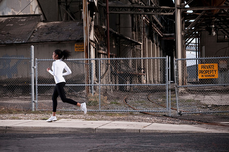 女人在工业城市街道上奔跑图片