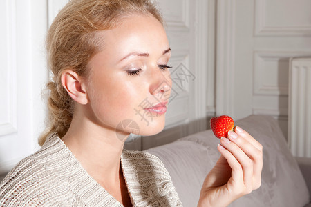 微笑的女人吃草莓背景图片