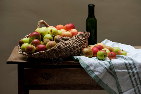桌上的苹果和葡萄酒篮子背景图片