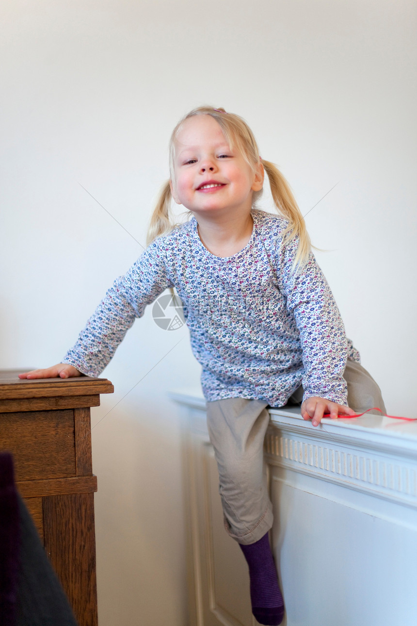 微笑的女孩在室内攀爬障碍物图片