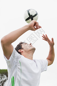 男子在野外踢足球图片