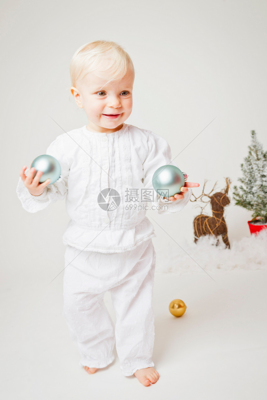 拿着圣诞装饰品的婴儿图片
