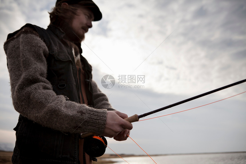 在湖中钓鱼的男人图片