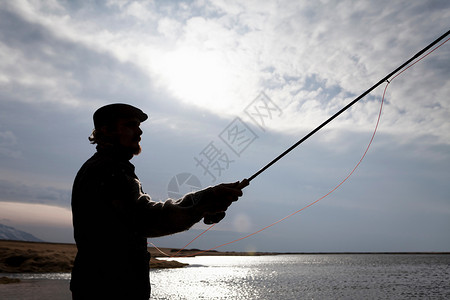 在湖中钓鱼的男人图片