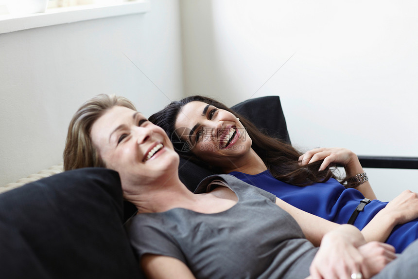 微笑的女人在沙发上休息图片
