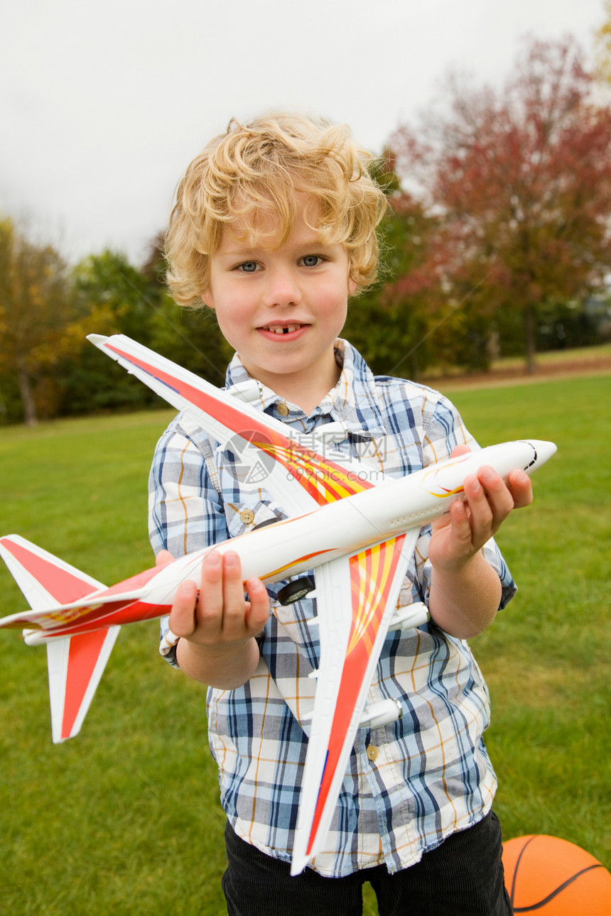 男孩在户外玩玩具飞机图片
