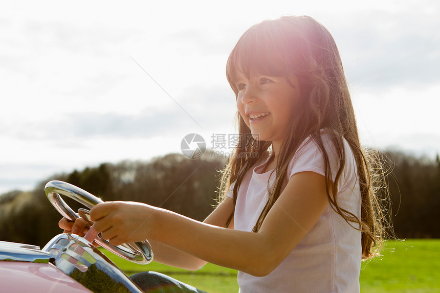 在野外驾驶玩具飞机的女孩图片