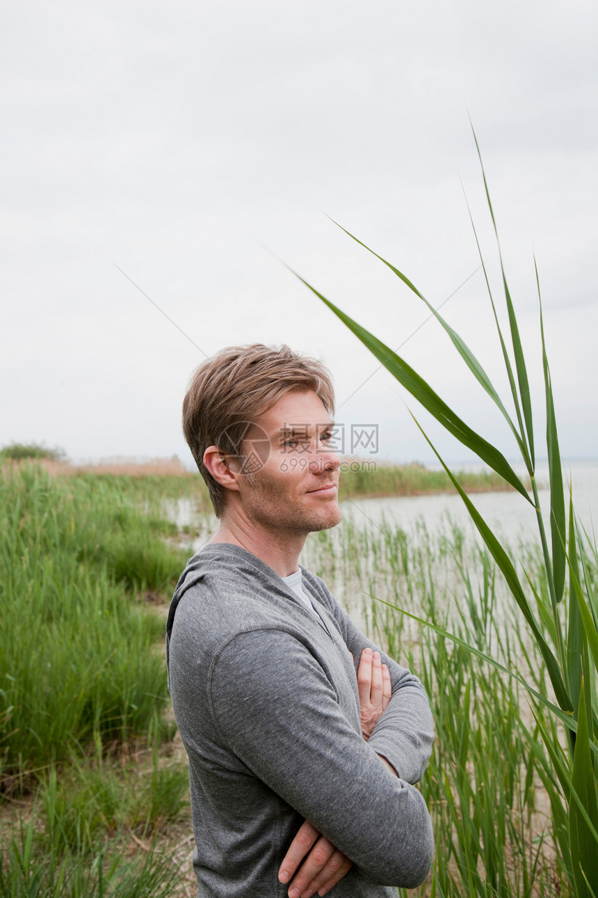 微笑的人站在湖边芦苇荡里图片