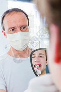 牙科医生在给病人检查牙齿图片