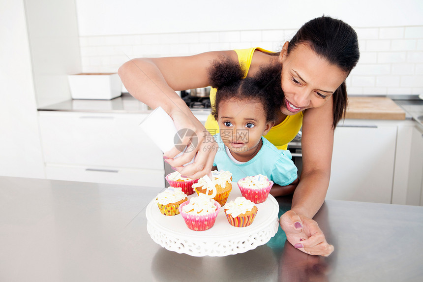 母亲和女儿一起做杯子蛋糕图片