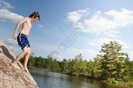 男孩在河边攀岩图片