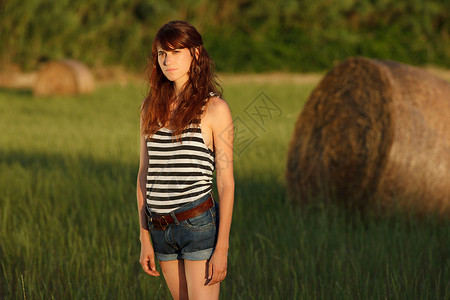 妇女站在草田里图片