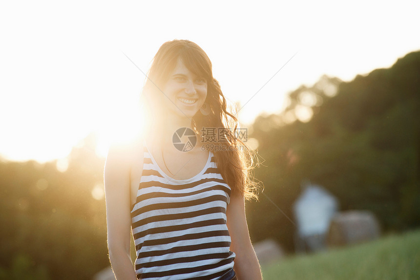 微笑的女性站在阳光下图片
